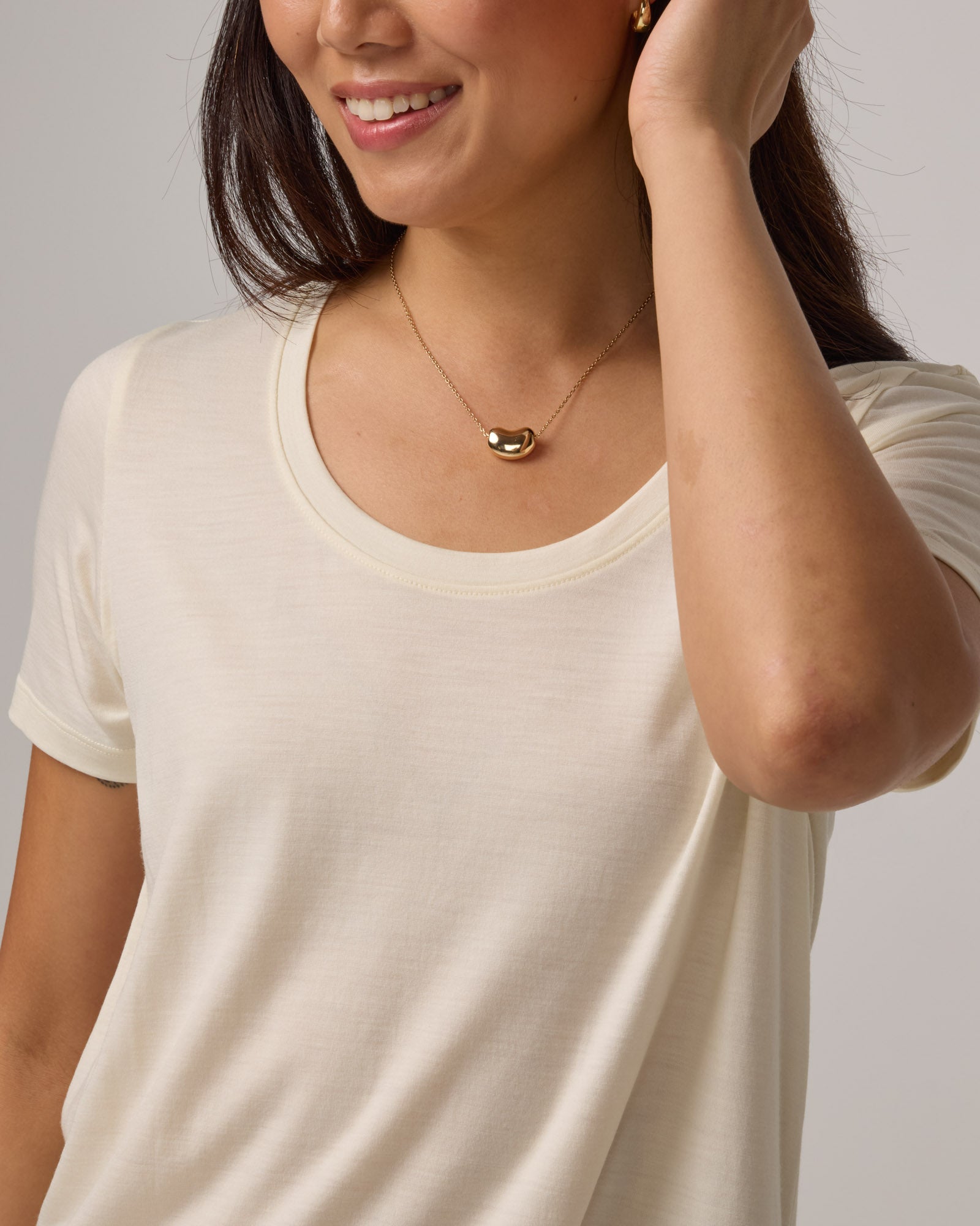 Model wearing Stella Scoop Neck Tee in Natural White. Stella Scoop Neck Tee is a merino wool short sleeve, scoop neck t-shirt available in sizes XS-3X.