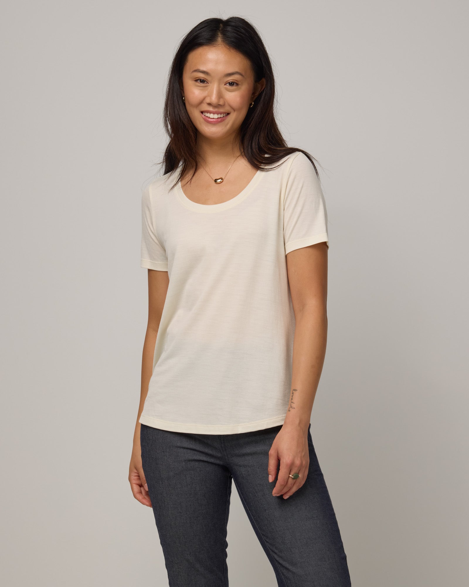 Model wearing Stella Scoop Neck Tee in Natural White. Stella Scoop Neck Tee is a merino wool short sleeve, scoop neck t-shirt available in sizes XS-3X.