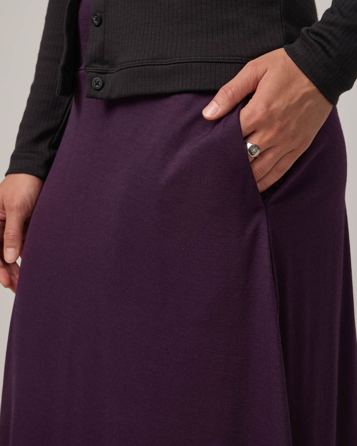 Model wearing Helena Midi Skirt in Cassis, a deep purple color. Helena Midi Skirt is a merino wool midi skirt with pockets available in sizes XS-3X.
