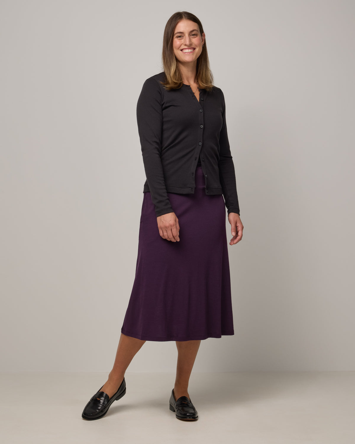 Model wearing Helena Midi Skirt in Cassis, a deep purple color. Helena Midi Skirt is a merino wool midi skirt with pockets available in sizes XS-3X.