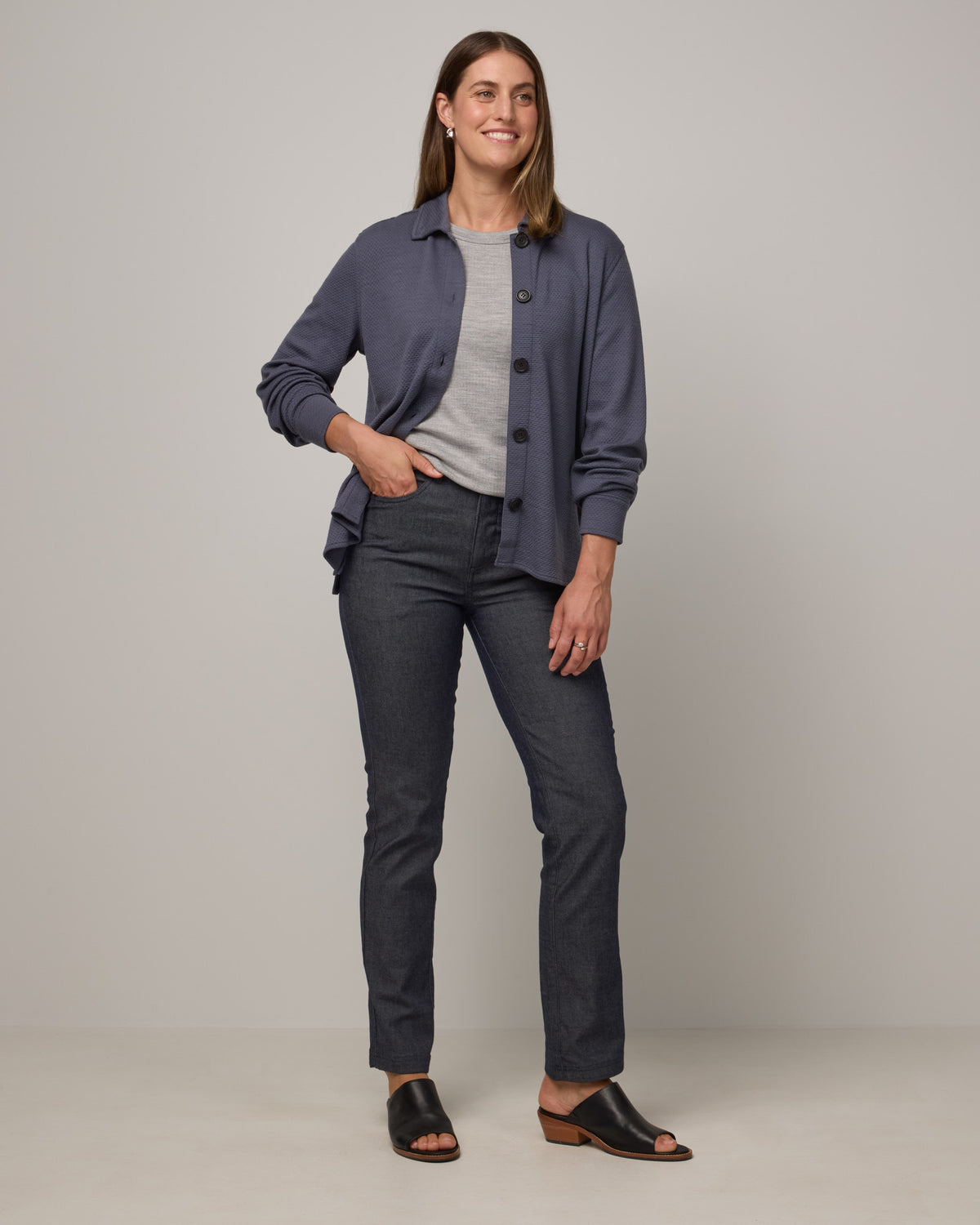 Model wearing Dani Relaxed Button-Front Shirt in Odyssey Gray, a slate blue-gray color. Dani Relaxed Button-Front Shirt is a merino wool long sleeve, collared button-down shirt available in sizes XS-3X.