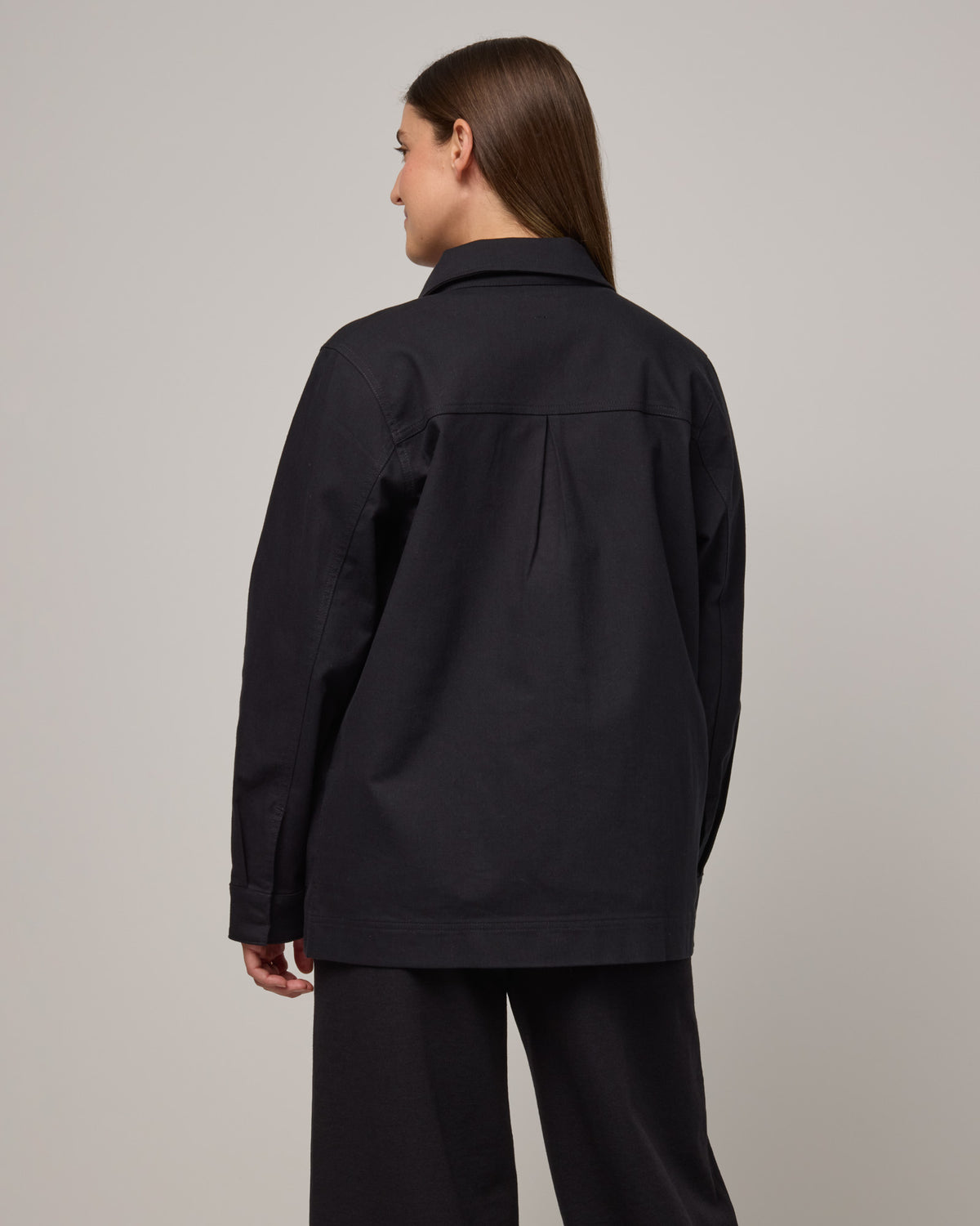 Model wearing Andi Denim Chore Jacket in Black. Andi Denim Chore Jacket is a merino wool long sleeve, collared, relaxed fit jacket available in sizes XS-XXL.