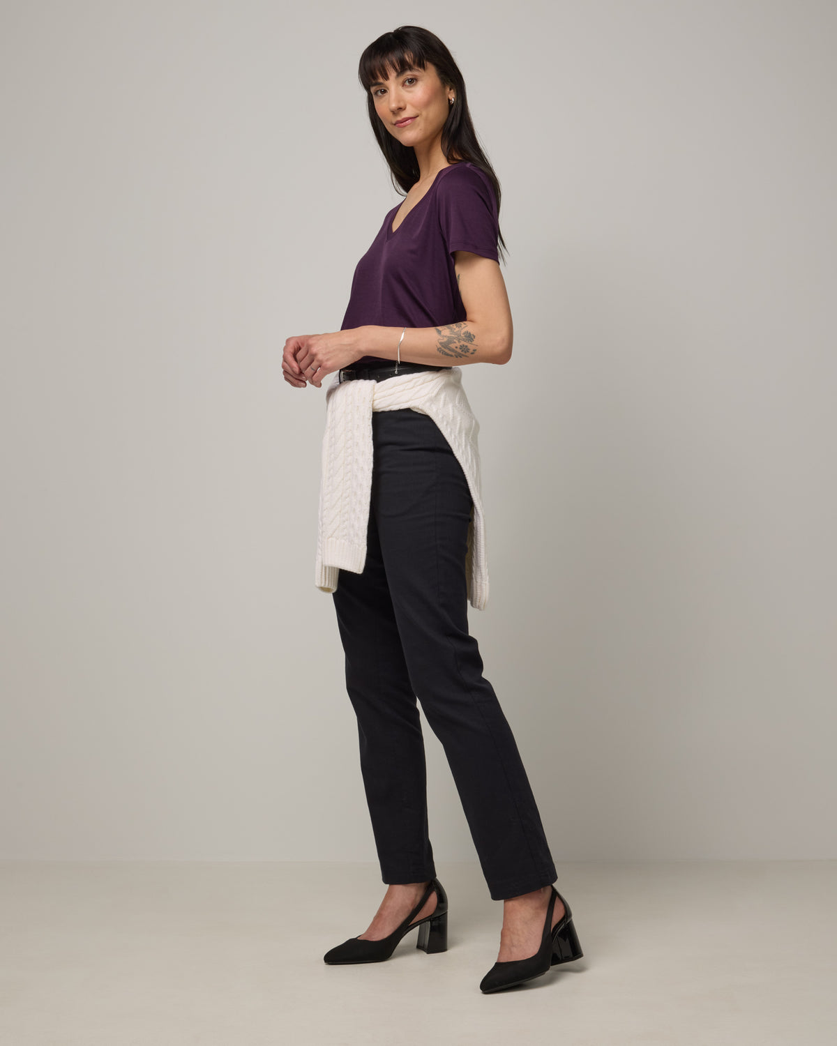 Model wearing Morgan V-Neck Tee in Cassis, a deep purple color. Morgan V-Neck Tee is a merino wool short sleeve, v-neck, regular fit tee available in sizes XS-3X.