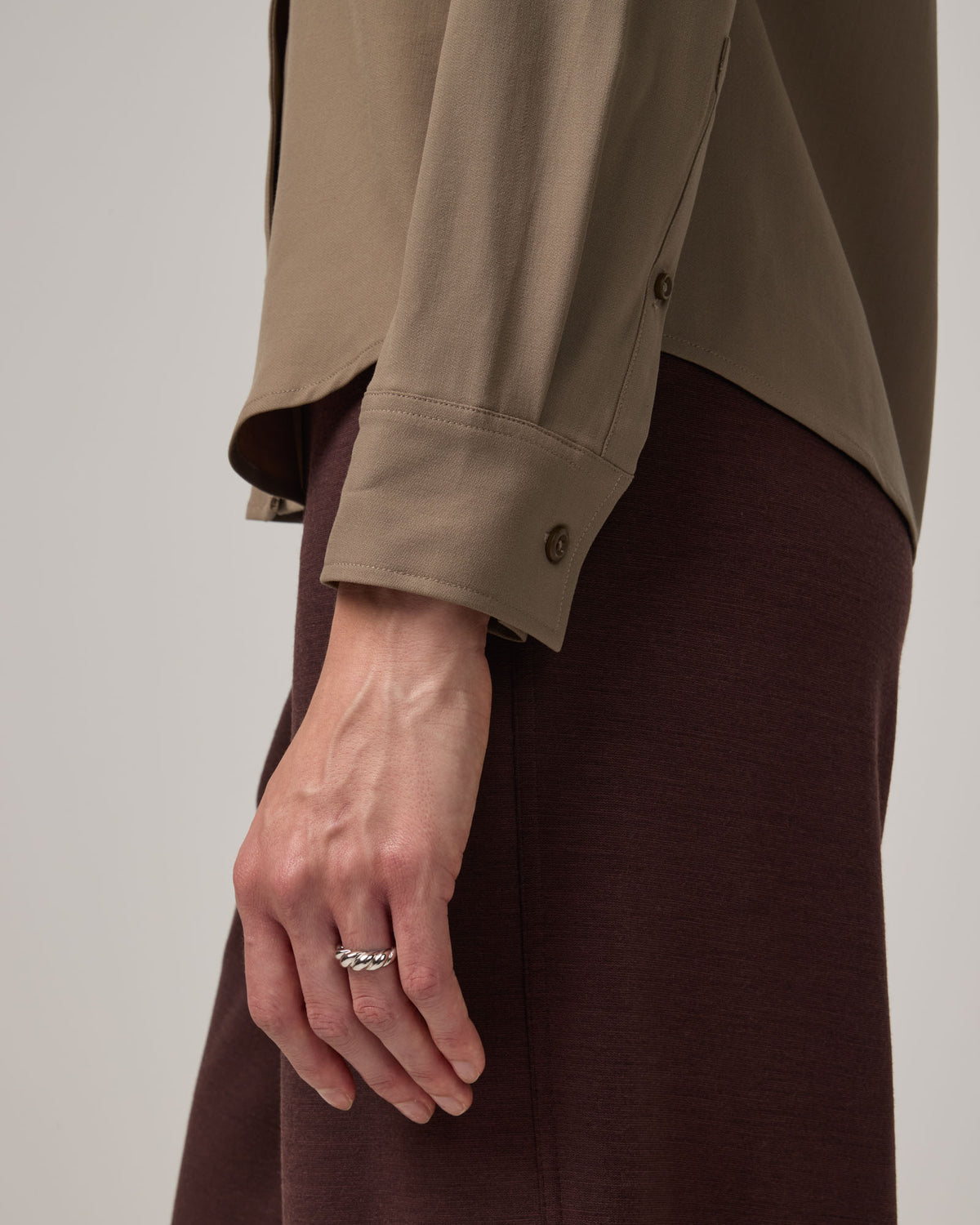 Model wearing Tiffany Button-Front Shirt in Walnut, a taupe brown color. Tiffany Button-Front Shirt is a merino wool long sleeve collared shirt available in sizes XS-XXL.