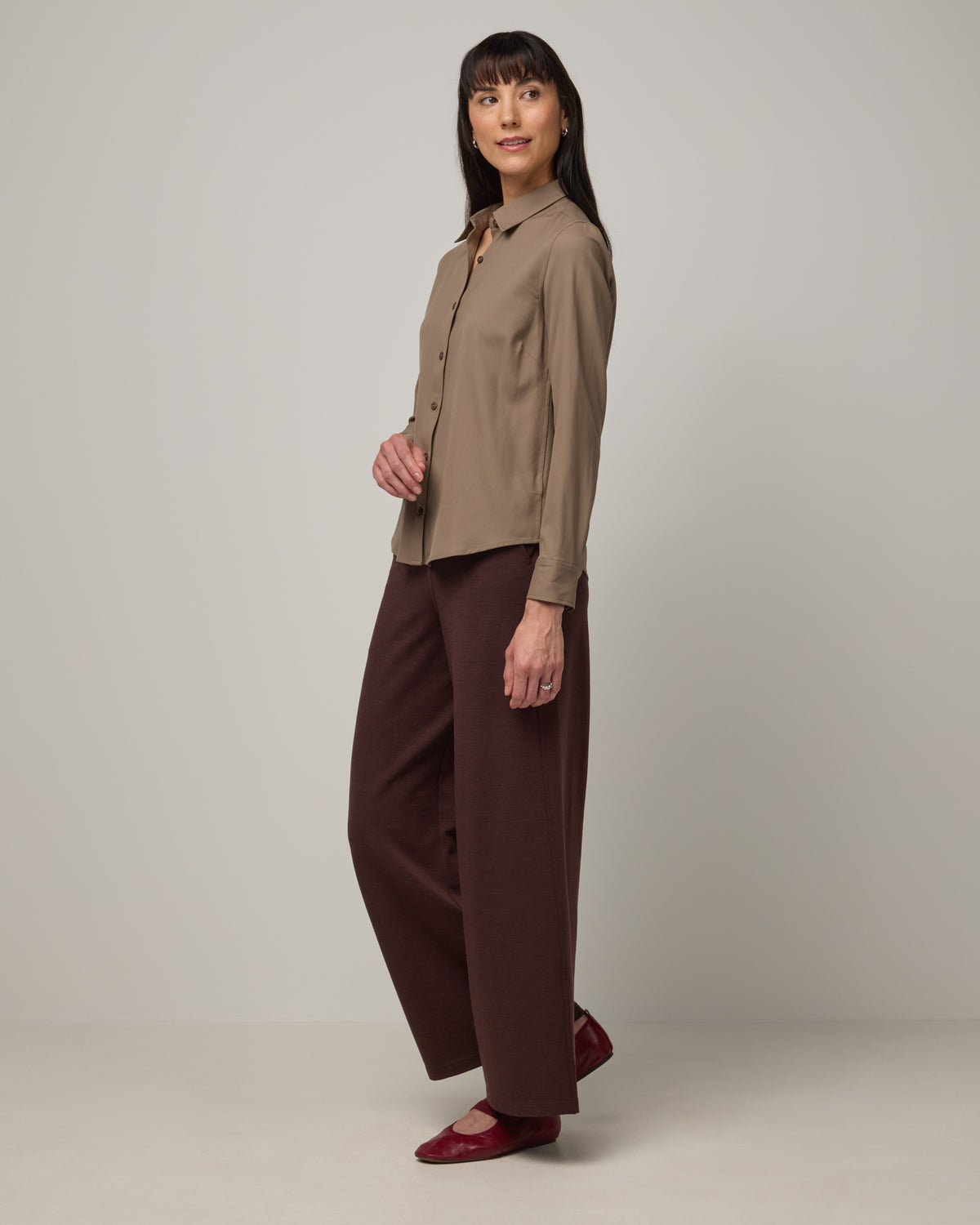 Model wearing Tiffany Button-Front Shirt in Walnut, a taupe brown color. Tiffany Button-Front Shirt is a merino wool long sleeve collared shirt available in sizes XS-XXL.