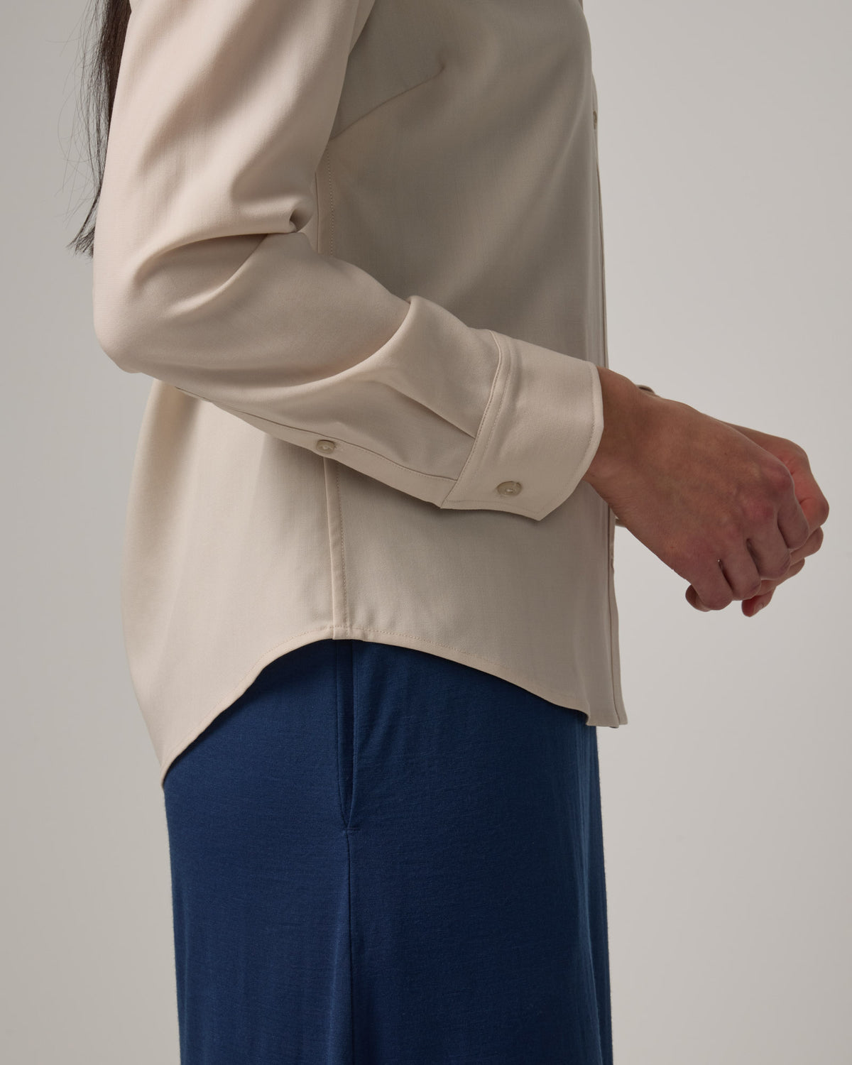 Model wearing Tiffany Button-Front Shirt in Oatmeal, a soft cream color. Tiffany Button-Front Shirt is a merino wool long sleeve collared shirt available in sizes XS-XXL.