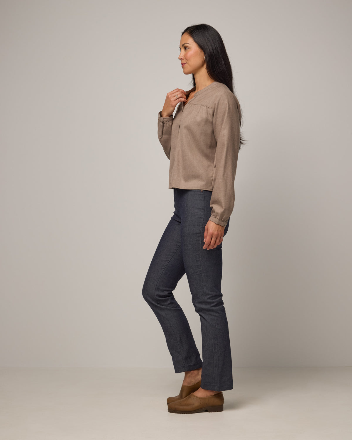 Model wearing Raquel Brushed Twill Top in Taupe Heather, a tan heathered color. Raquel Brushed Twill Top is a 100% merino wool long sleeve, split collar button-front shirt available in sizes XS-XXL.