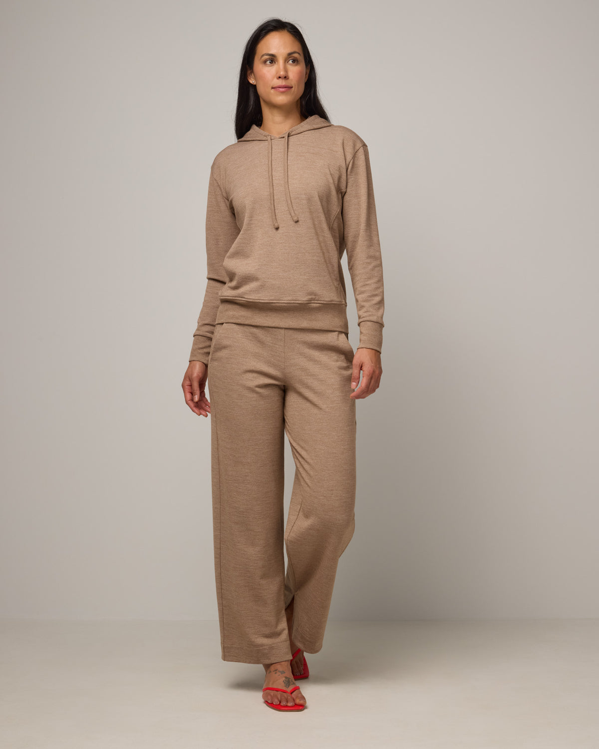 Model wearing Aspen Wide Leg Sweatpants in Camel Heather, a warm taupe heather color. Aspen Wide Leg Sweatpant is a merino wool, elastic waist pant available in sizes XS-3X. 