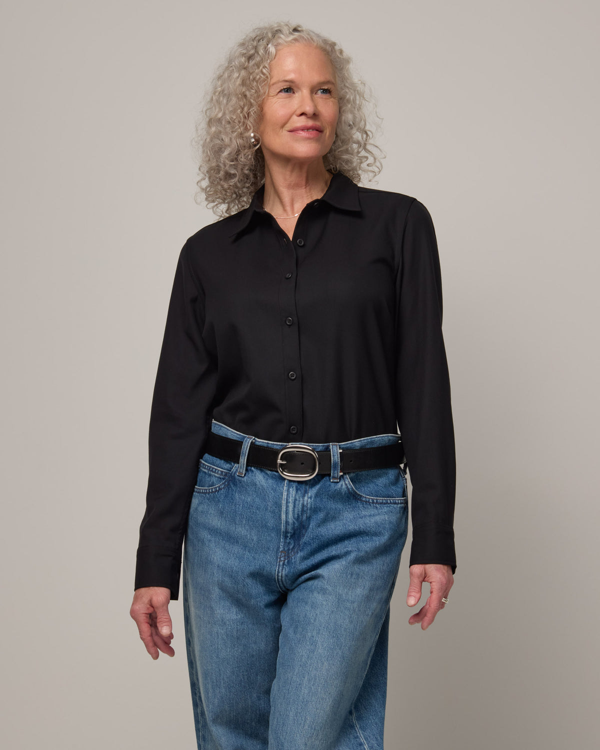 Model wearing Tiffany Button-Front Shirt in Black. Tiffany Button-Front Shirt is a merino wool long sleeve collared shirt available in sizes XS-XXL.