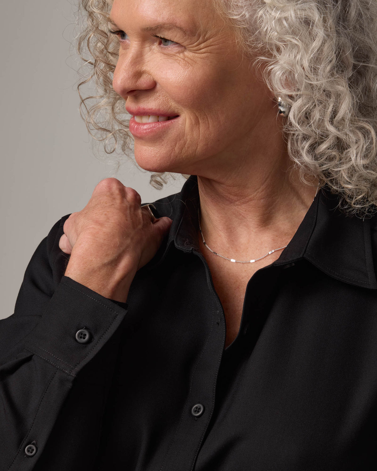 Model wearing Tiffany Button-Front Shirt in Black. Tiffany Button-Front Shirt is a merino wool long sleeve collared shirt available in sizes XS-XXL.