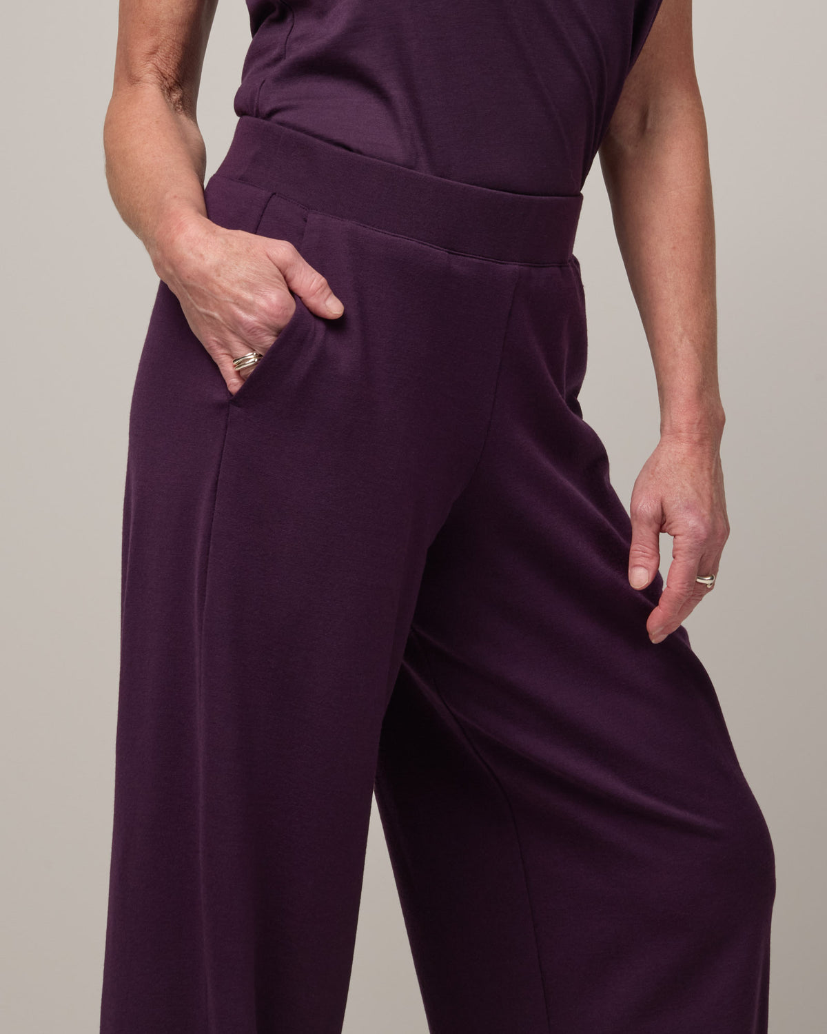 Model wearing Aspen Wide Leg Sweatpantsin Cassis, a deep purple color. Aspen Wide Leg Sweatpant is a merino wool, elastic waist pant available in sizes XS-3X. 