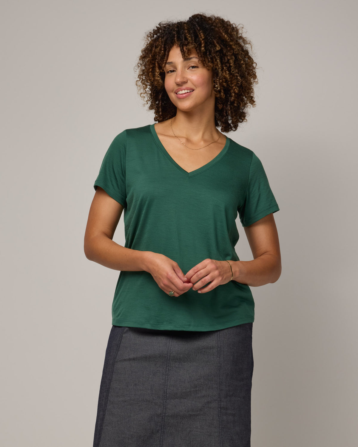 Model wearing Morgan V-Neck Tee in Emerald green. Morgan V-Neck Tee is a merino wool short sleeve, v-neck, regular fit tee available in sizes XS-3X.