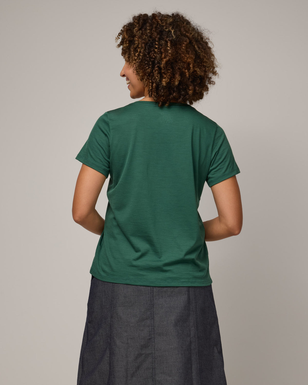 Model wearing Morgan V-Neck Tee in Emerald green. Morgan V-Neck Tee is a merino wool short sleeve, v-neck, regular fit tee available in sizes XS-3X.