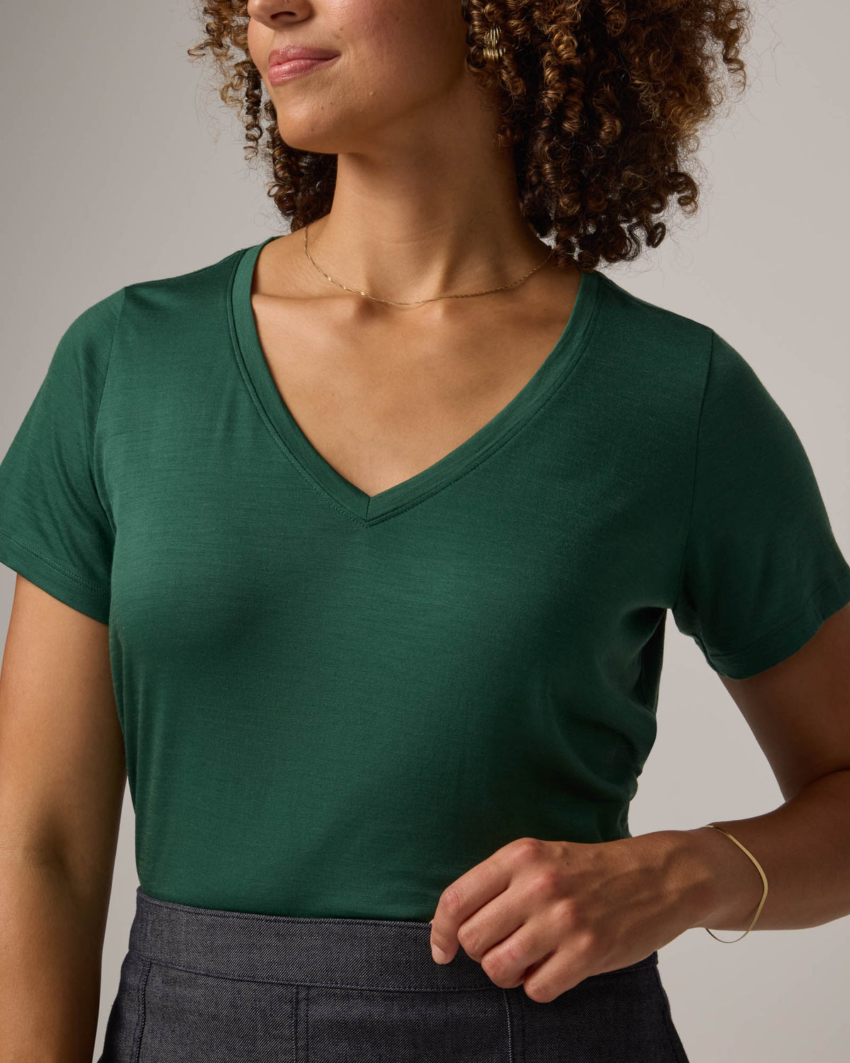 Model wearing Morgan V-Neck Tee in Emerald green. Morgan V-Neck Tee is a merino wool short sleeve, v-neck, regular fit tee available in sizes XS-3X.